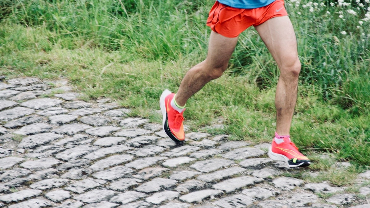 a man running down a cobblestone road
